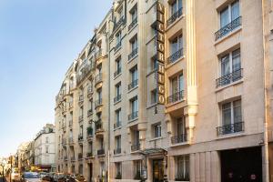 un panneau d'hôtel sur le côté d'un bâtiment dans l'établissement Hôtel Victor Hugo Paris Kléber, à Paris