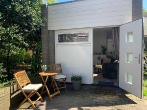 a white garage door with chairs and a table at Mouton Beach Lodge in Petten