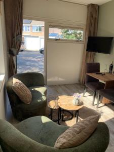 a living room with two chairs and a table at Mouton Beach Lodge in Petten