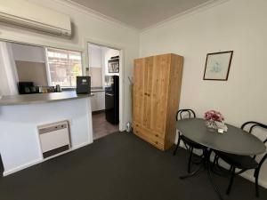 a living room with a table and a kitchen at Motel Bombala in Bombala