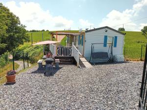 a tiny house with a porch and a patio at ROUPILLON A JANET in Curvalle