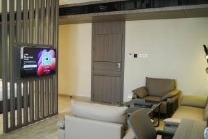 a living room with a tv and chairs at Hotel PRD Palace in Saharsa