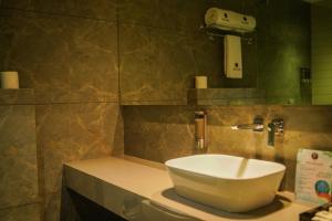 a bathroom with a white sink and a mirror at Hotel PRD Palace in Saharsa