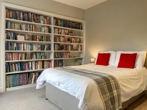 a bedroom with a bed and book shelves filled with books at Victoria Apartment 1 in Tarporley