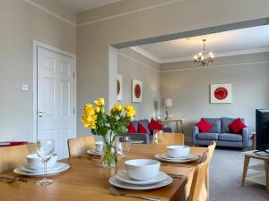 a dining room with a table with yellow flowers on it at Victoria Apartment 1 in Tarporley