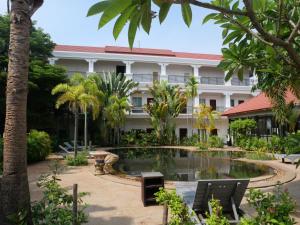 a resort with a pool in front of a building at STC Hotel School in Phumĭ Réach Born (1)