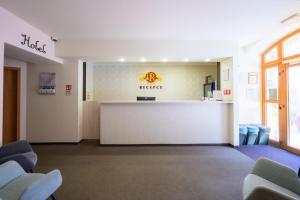 a waiting room with a reception desk and chairs at Hotel Roudna in Pilsen