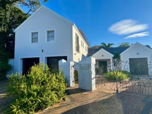a white house with a fence in front of it at Serenity Suite in Somerset West