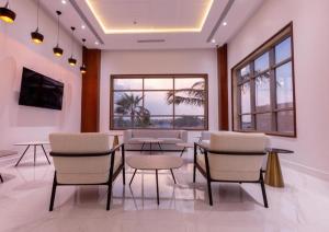 a dining room with chairs and a table and windows at فندق الراية الفندقية in Jazan