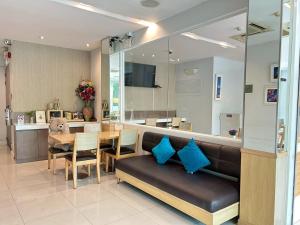 a dining room with a couch and a table with blue pillows at S3 Residence Park in Bangkok