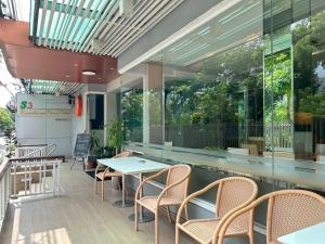 a patio with tables and chairs and windows at S3 Residence Park in Bangkok