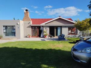a house with a car parked in front of it at Rosa Villa in Hermanus