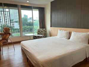 a hotel room with a large bed and a teddy bear at S3 Residence Park in Bangkok