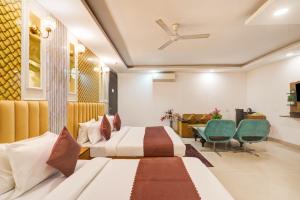 a hotel room with two beds and a table and chairs at Hotel Olive Aero Suites Near Delhi IGI Airport in New Delhi