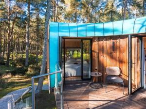 a house with a blue roof with a bed on a deck at Kanna-Qu7625 in Chipping Norton
