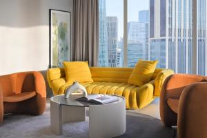 a living room with a yellow couch and a table at Kimpton KAFD Riyadh by IHG in Riyadh