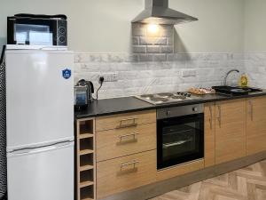 a kitchen with a white refrigerator and a stove at Primrose - Uk49360 in Bridlington