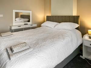 a bedroom with a large white bed with a mirror at Primrose - Uk49360 in Bridlington