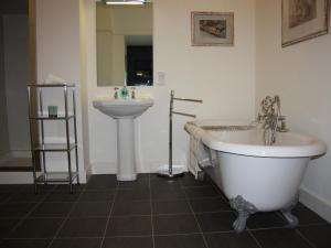 a bathroom with a bath tub and a sink at Moat House 1 - Ukc4887 in Fort Augustus