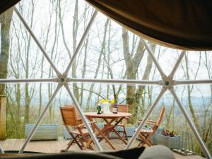 a room with a table and chairs in a tent at The Tree Dome - Ukc6979 in Ludlow