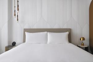a white bed with white pillows in a bedroom at Kimpton KAFD Riyadh by IHG in Riyadh +85 photos