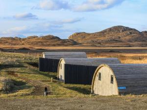 an old barn in a field with mountains in the background at Katie's Pod in Acharacle