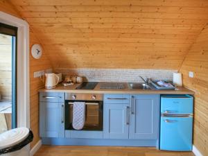 a kitchen with blue cabinets and a sink at Katie's Pod in Acharacle