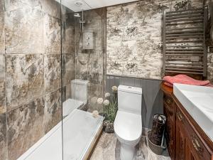 a bathroom with a shower and a toilet and a sink at Bert's Barn in Firsby +3 photos