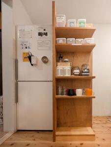 a refrigerator in a kitchen next to a shelf at Shizuya KYOTO in Kyoto