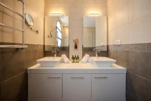 a bathroom with two sinks and a large mirror at Carmelo I MOD Villa in Herzliya B