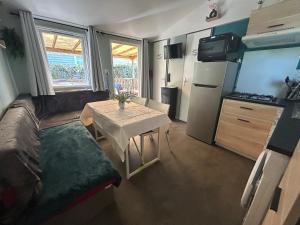 a small room with a table and a kitchen at Le SaraLéna in Torreilles