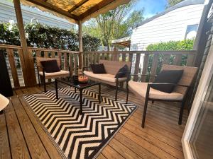 a patio with two chairs and a table on a deck at Le SaraLéna in Torreilles