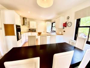 a kitchen with a black table and white chairs at Lochindaal in Tarbert