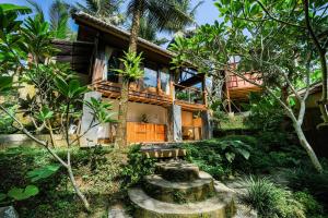 a house with a garden in front of it at Ubud Jungle Stay - Mahari by WAHM in Ubud