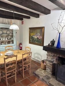 a dining room with a wooden table and a fireplace at Iregi Natura Casa Rural in Oskotz