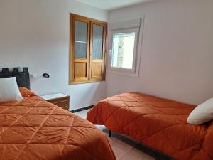 a bedroom with two beds and a window at Casa María in Baltar