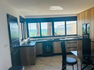 a kitchen with a sink and a counter with windows at Ferienhaus direkt am Strand mit Terrasse und Meerblick in Torrevieja in Punta Prima