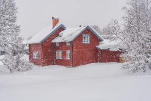 a red brick house covered in snow at Hemgården i Storsätern - Grövelsjöfjällen in Grövelsjön