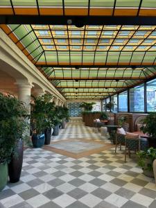 a lobby with potted plants and a glass ceiling at Grand Hotel Bristol in Stresa