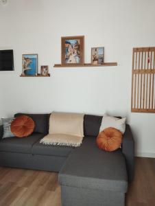 a living room with a gray couch with orange pillows at Gaia in Posidhonía