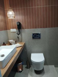 a bathroom with a white sink and a toilet at Gaia in Posidhonía +4 photos