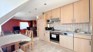 a kitchen with wooden cabinets and a table with a counter top at Agroturystyka Düsselkamp Tumiany in Barczewo