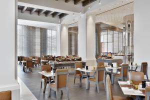 a dining room with tables and chairs and a restaurant at JW Marriott Mumbai Sahar Airport in Mumbai