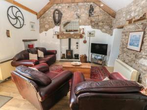 a living room with leather furniture and a fireplace at Butterslade in Swansea