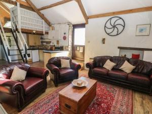 a living room with leather couches and a coffee table at Butterslade in Swansea +11 photos