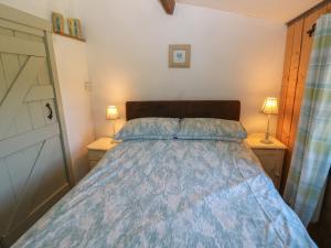 a bedroom with a bed with a blue comforter at Butterslade in Swansea