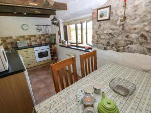 a kitchen with a table and a kitchen with a stone wall at Ramsgrove in Swansea