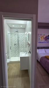 a bathroom with a shower and a sink and a bed at ILBE bed & breakfast in Campobasso +62 photos