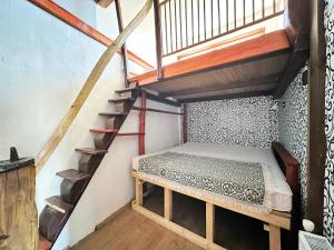 a bedroom with a bunk bed and a staircase at Ziggiho chalupa in Pliešovce