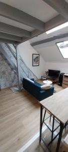 a living room with a couch and a table at Studio Arc en Ciel in Bouguenais